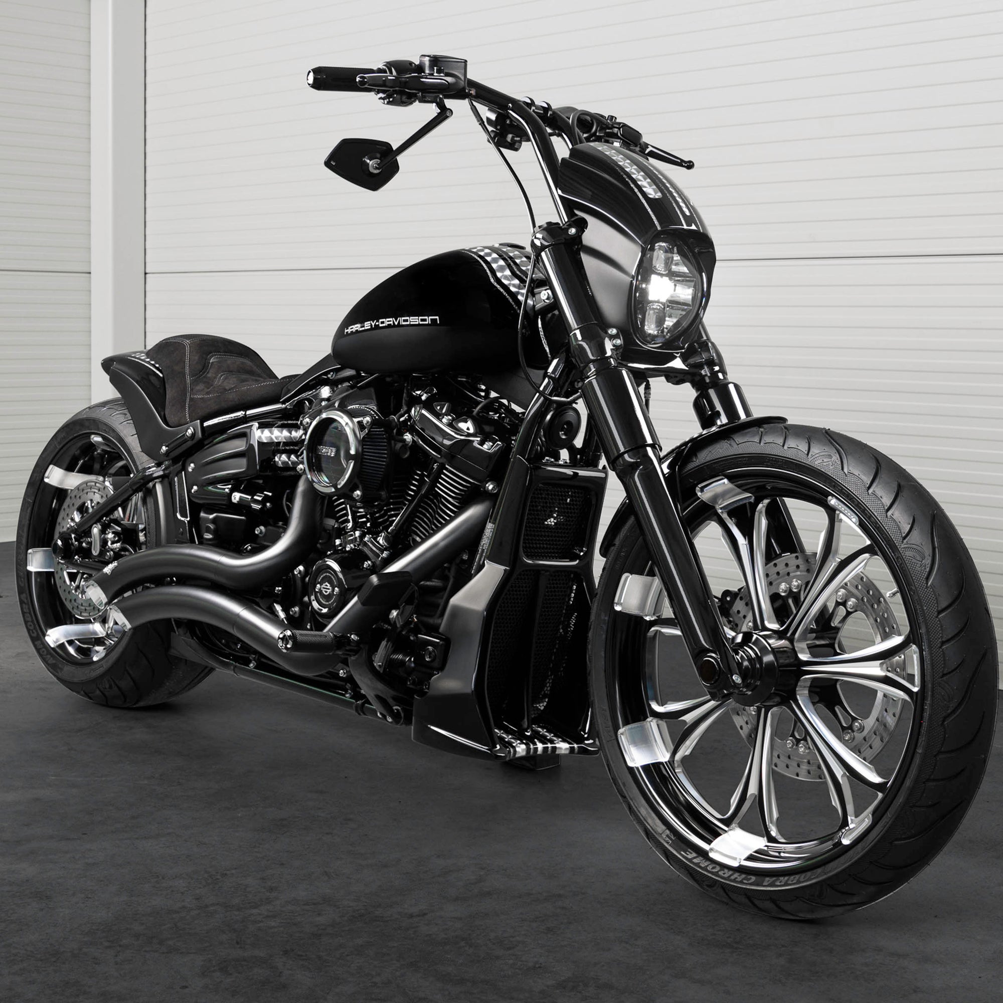 Harley Davidson motorcycle with Killer Custom parts from the front in a white modern bike shop