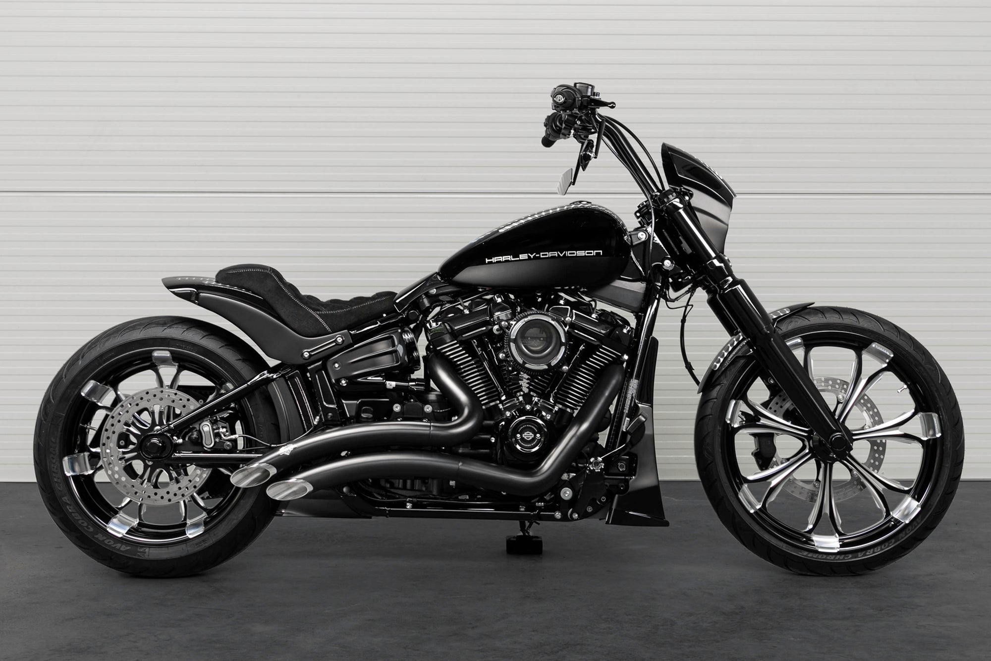 Modified Harley Davidson Breakout motorcycle with Killer Custom parts from the side in a white modern bike shop
