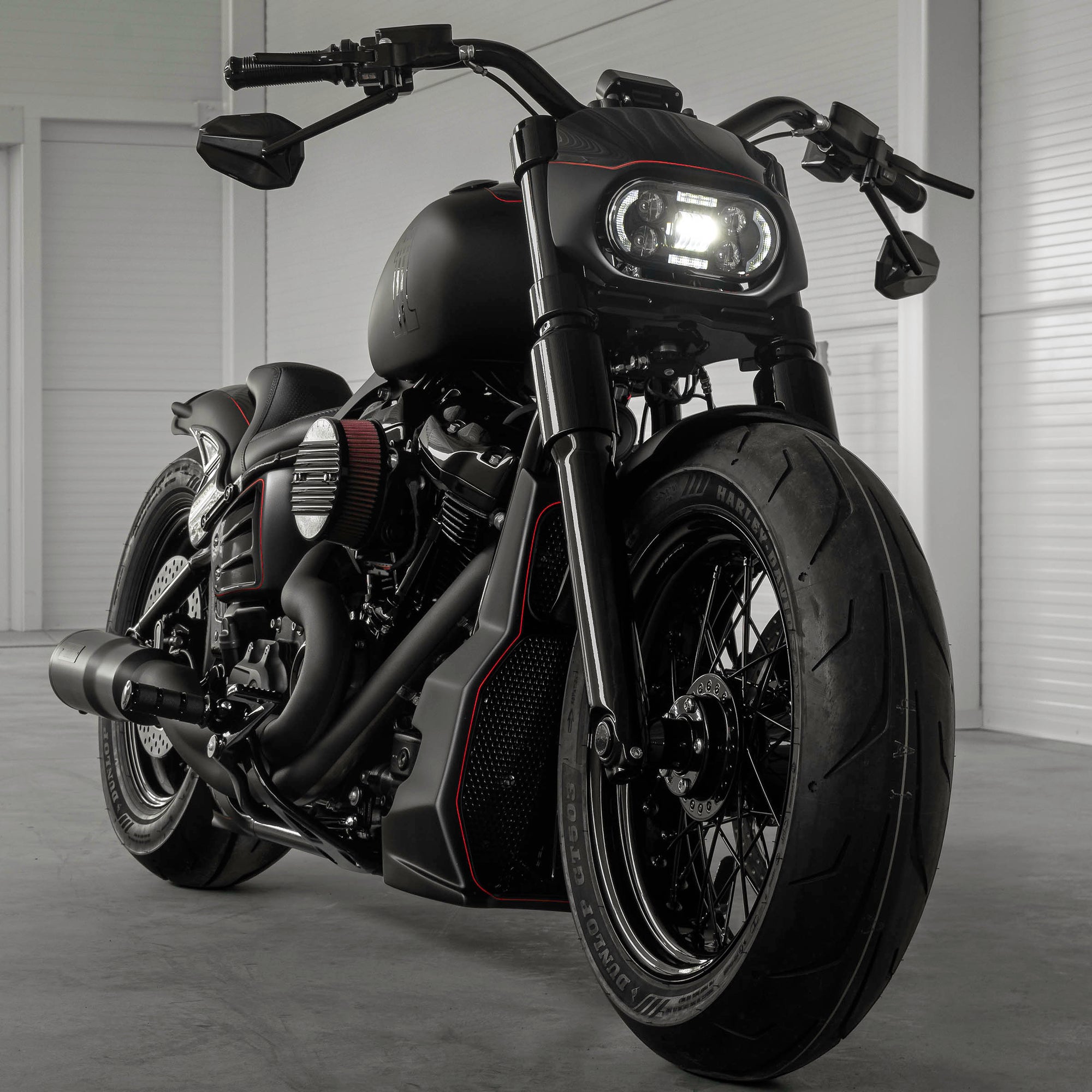 Harley Davidson motorcycle with Killer Custom parts from the front in a modern white garage