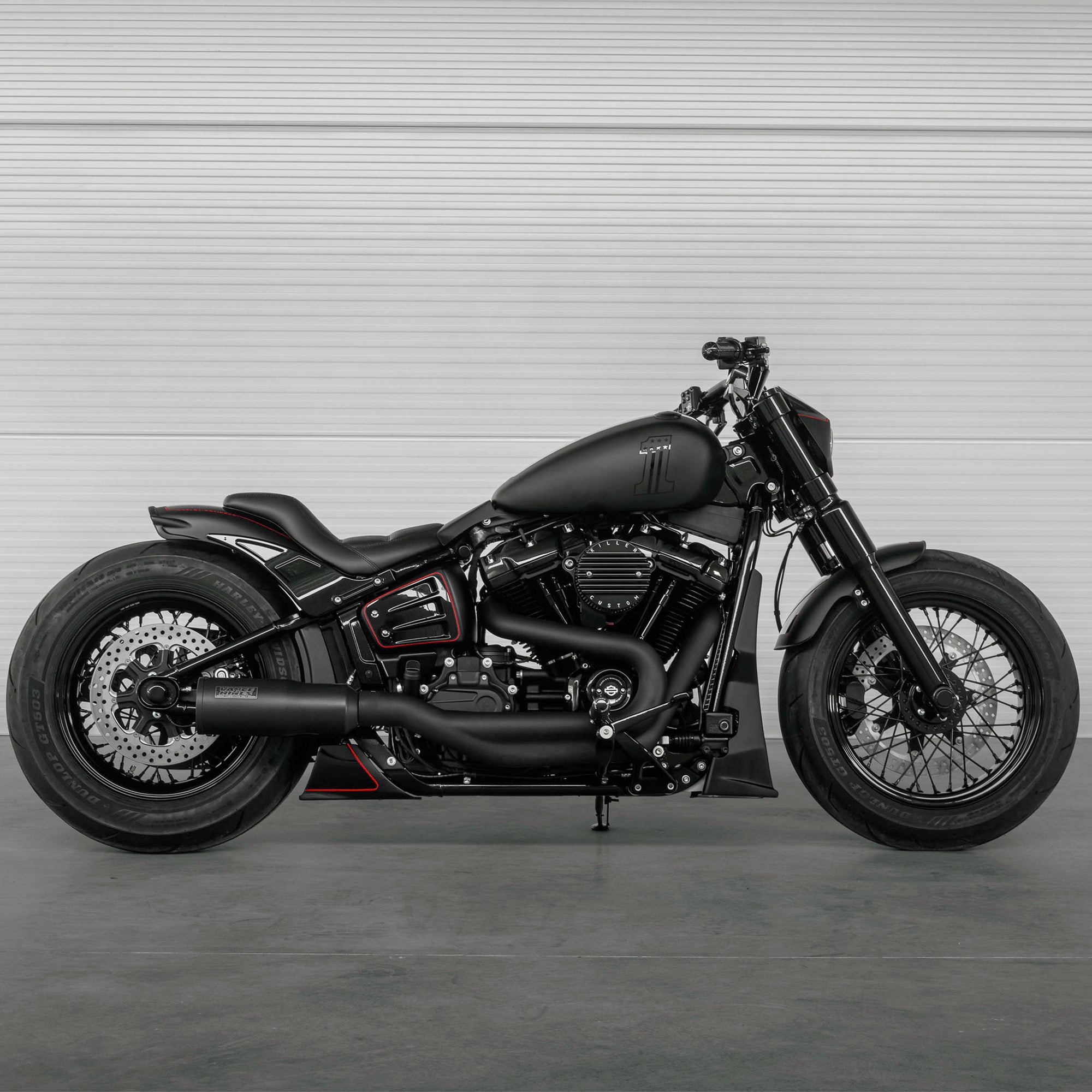 Modified Harley Davidson Softail Standard motorcycle with Killer Custom parts from the side in a modern white garage