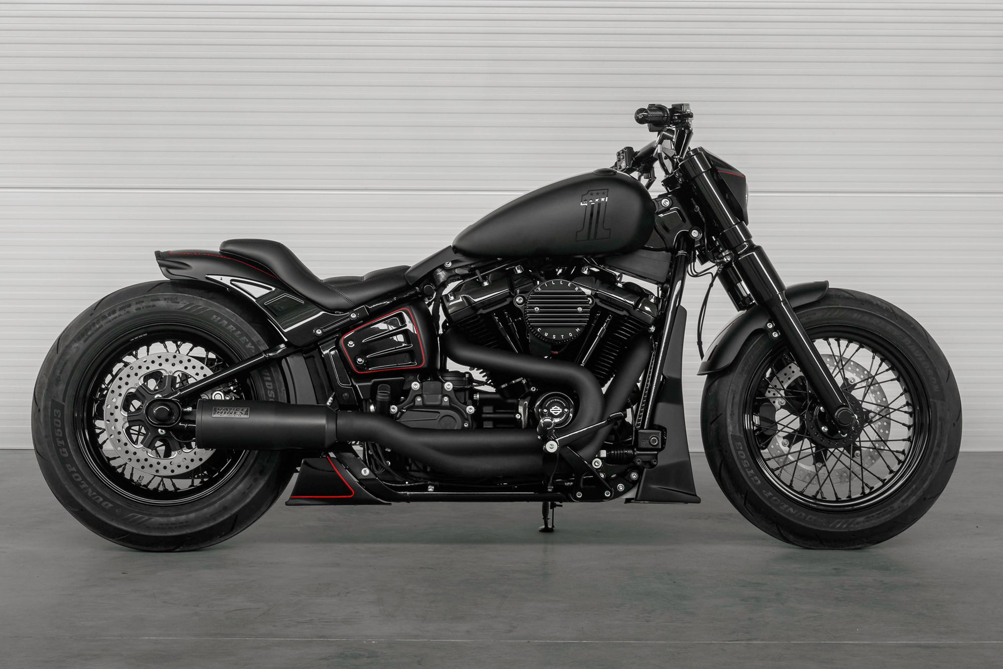 Modified Harley Davidson Softail Standard motorcycle with Killer Custom parts from the side in a modern white garage