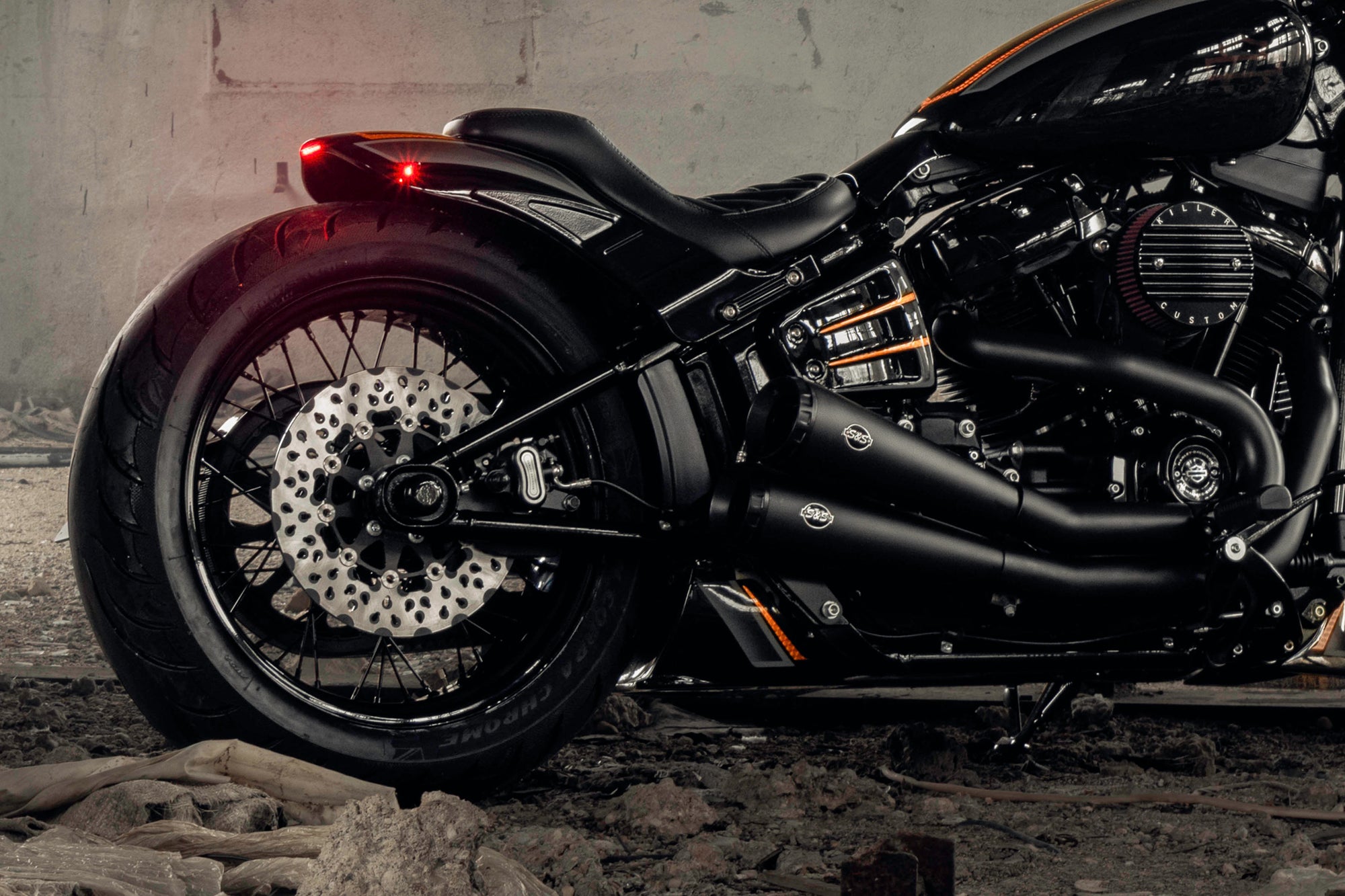 Zoomed Harley Davidson motorcycle with Killer Custom parts from the side in an abandoned building