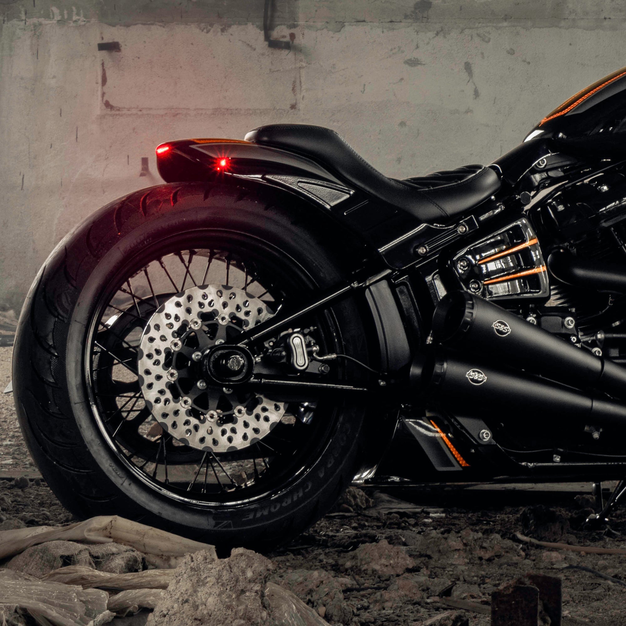 Zoomed Harley Davidson motorcycle with Killer Custom parts from the side in an abandoned building