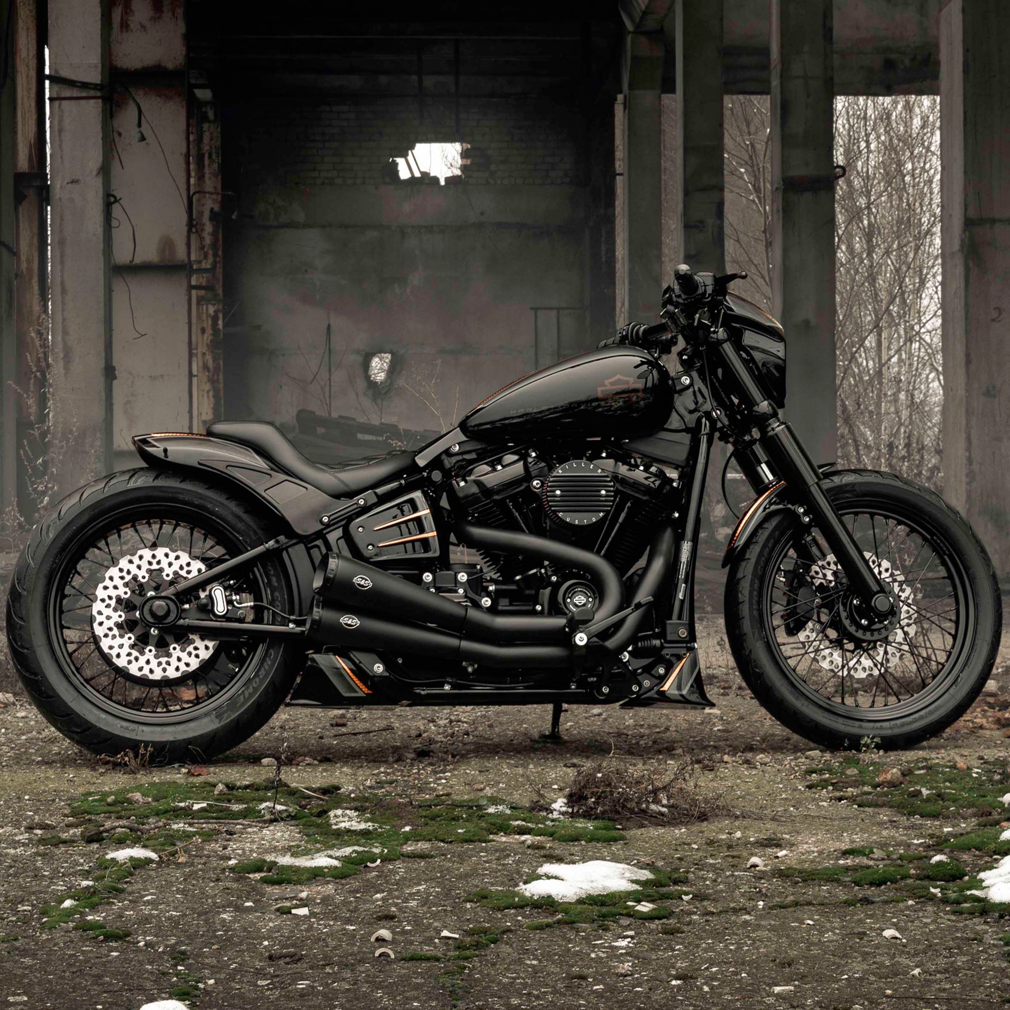 Harley Davidson motorcycle with Killer Custom parts from the side outside in an abandoned environment