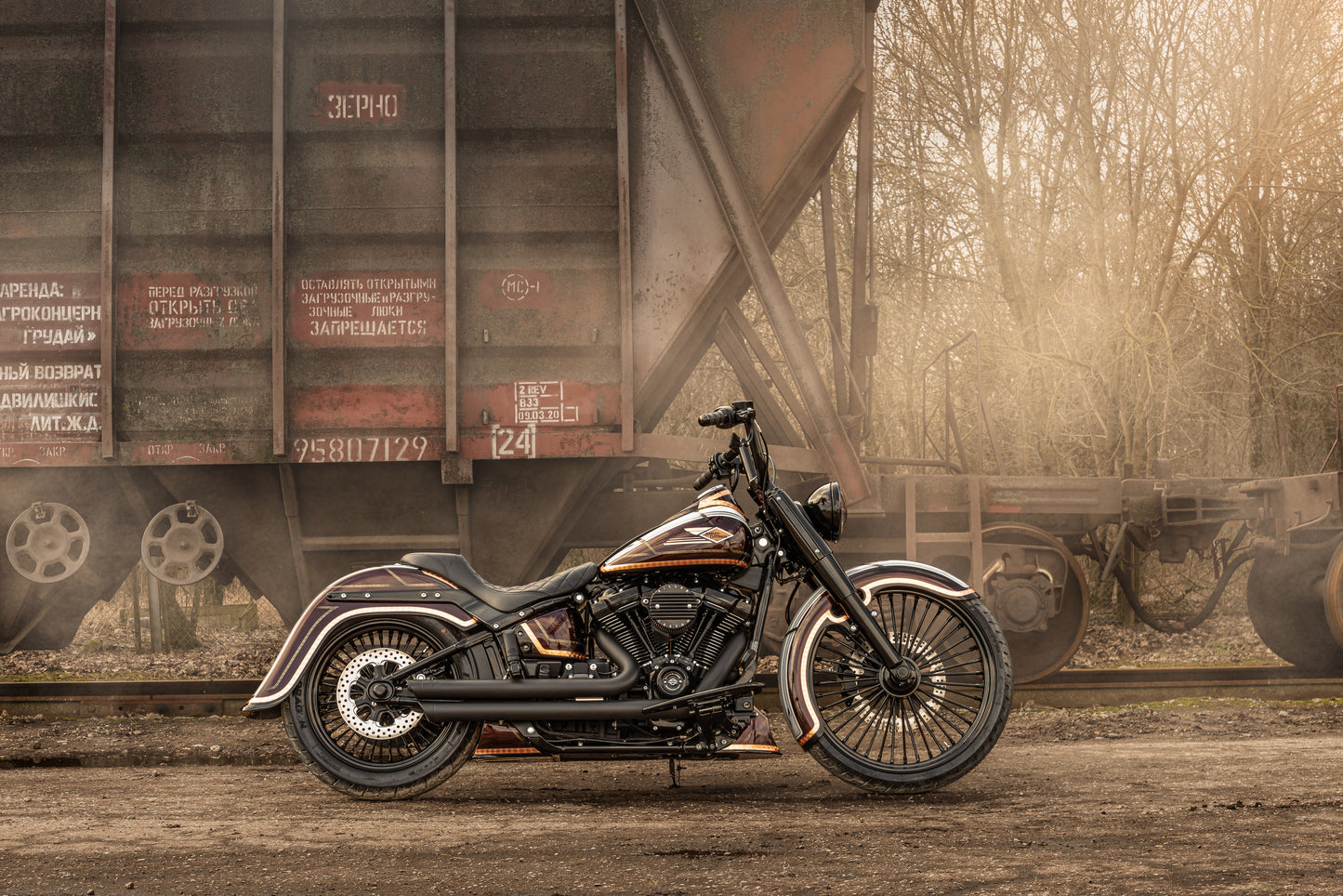 Harley Davidson motorcycle with Killer Custom front wrap fender from the side at a railway station