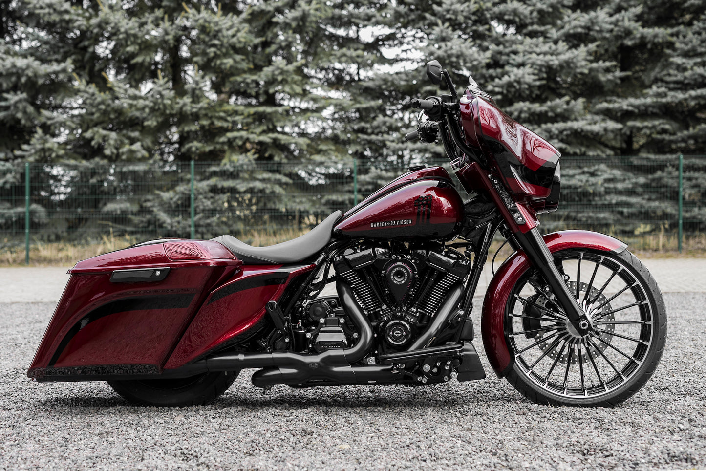 Harley Davidson motorcycle with Killer Custom rear shock lowering kit from the side with blurred trees in the background