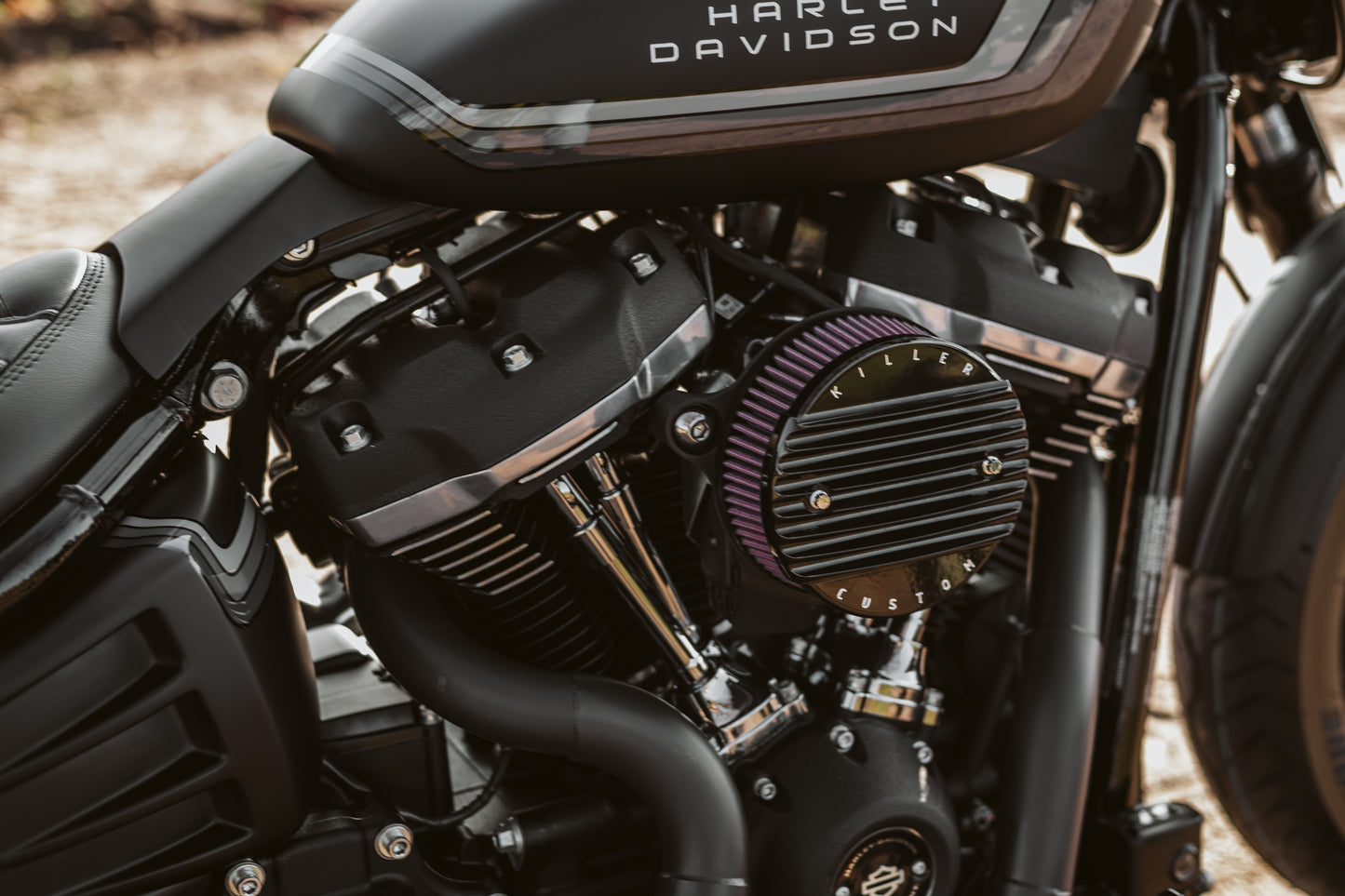 Zoomed Harley Davidson motorcycle with Killer Custom air filter cover for air cleaner kit from the side blurry background
