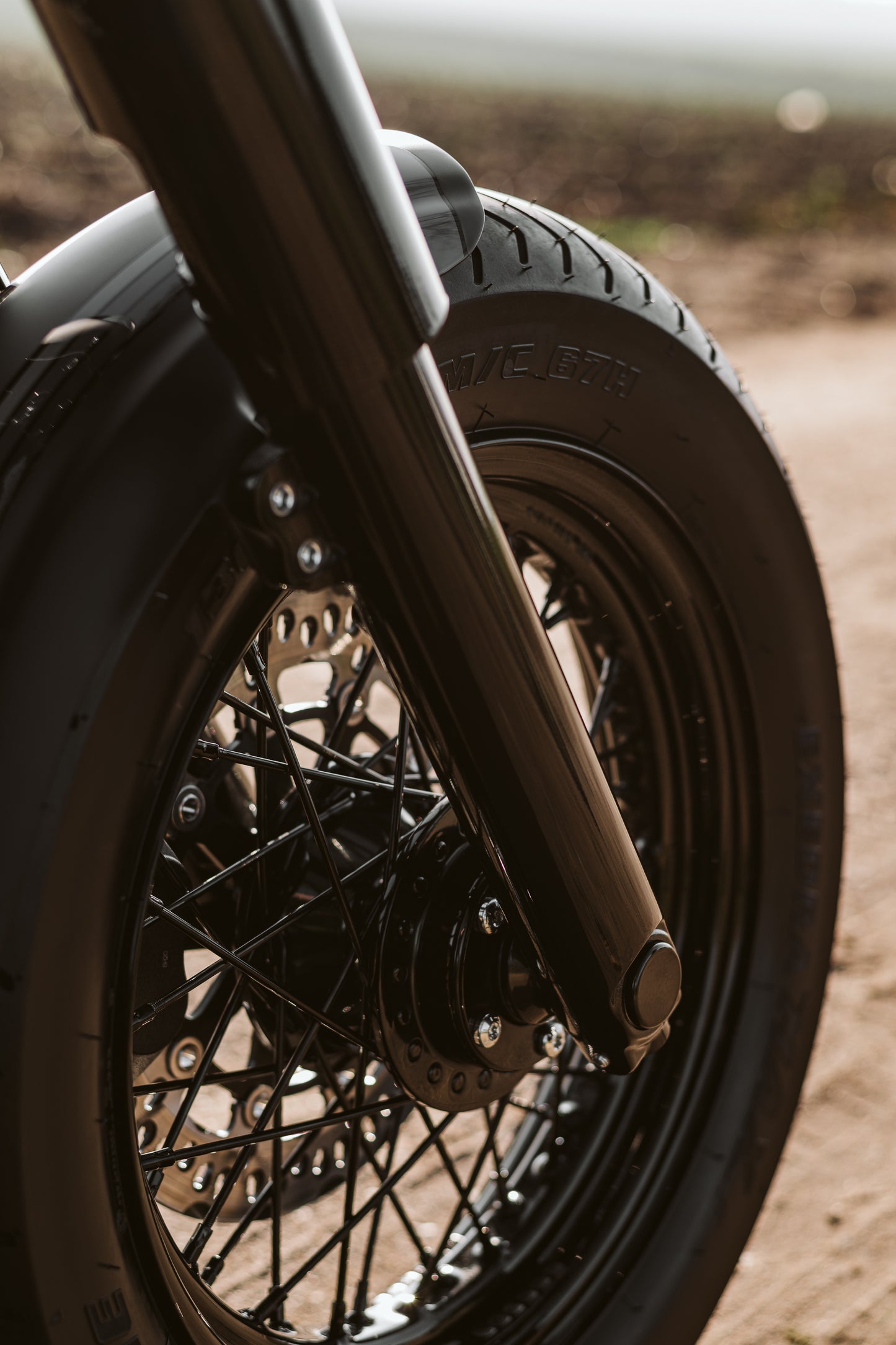 Zoomed Harley Davidson motorcycle with Killer Custom front wheel spacer kit blurry background