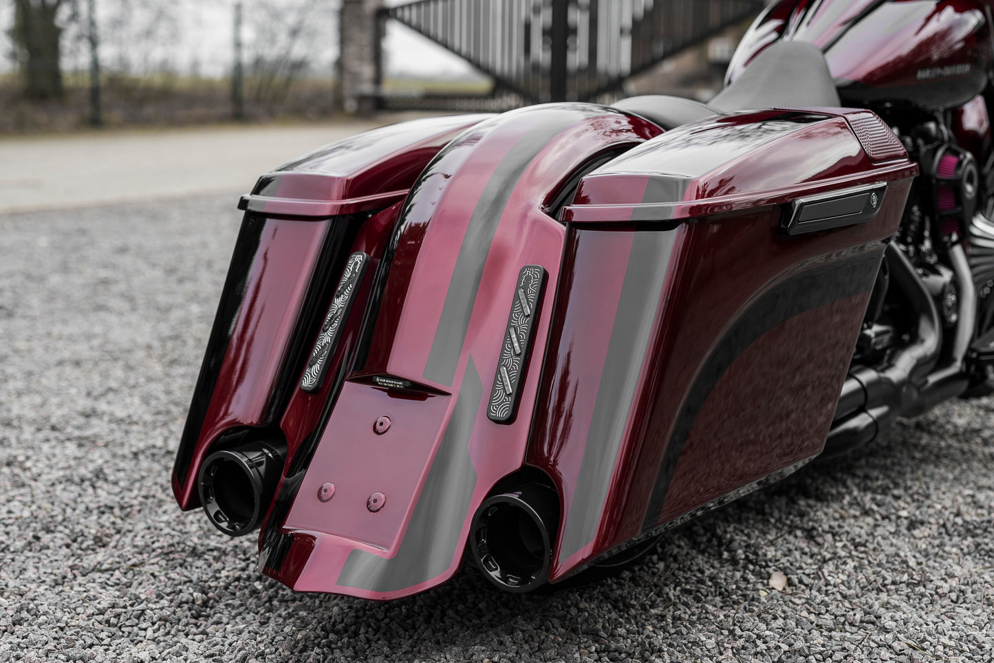 Harley Davidson motorcycle with Killer Custom touring rear fender from the rear with a blurry fence in the background