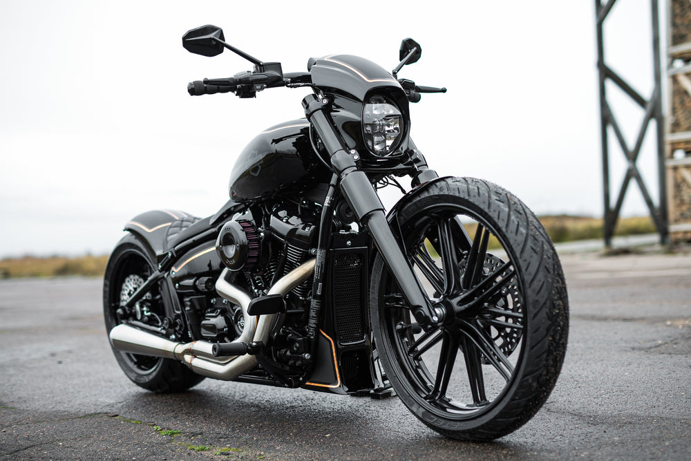 Harley Davidson motorcycle with Killer Custom front axle cover set from the front in an industrial environment