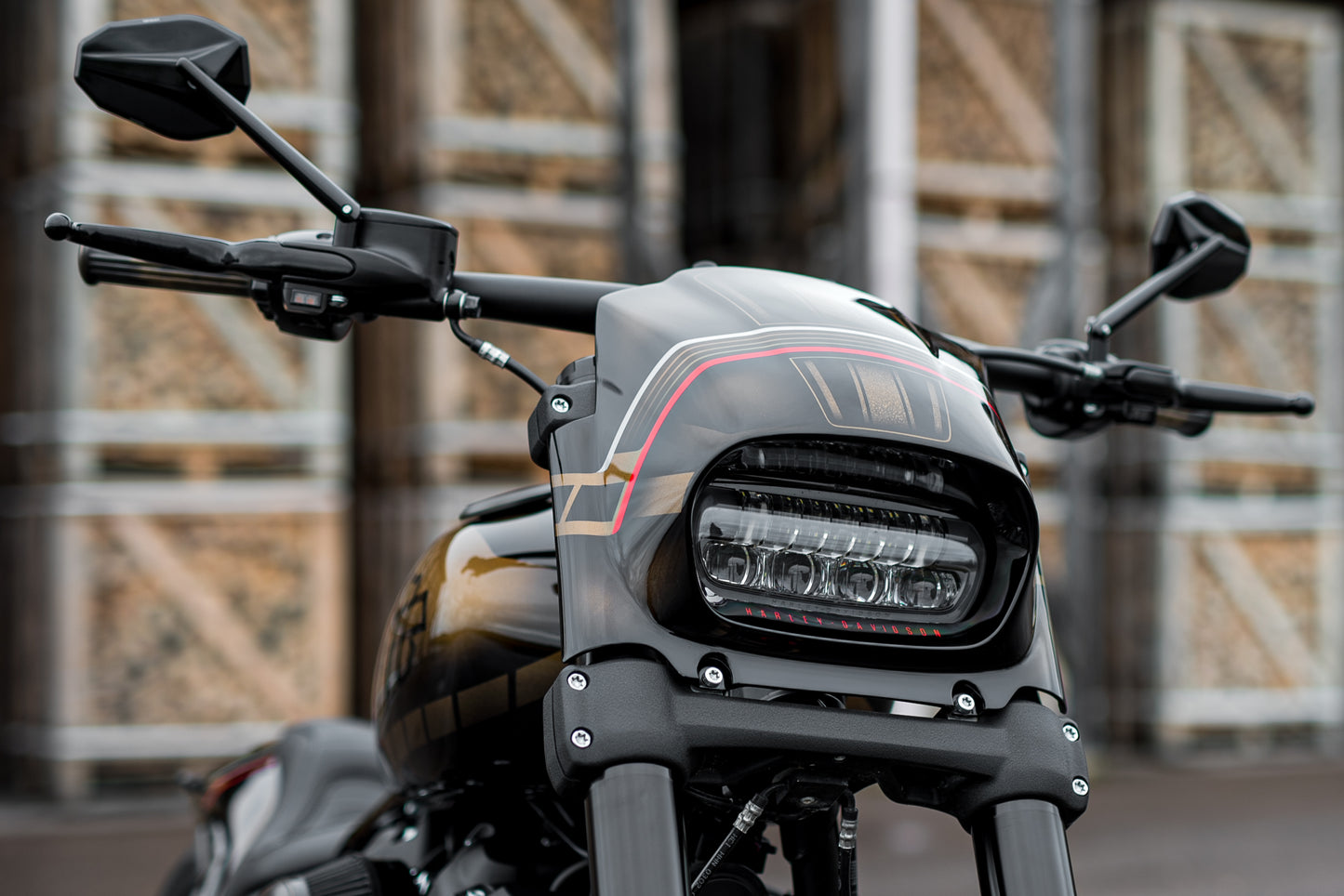 Zoomed Harley Davidson motorcycle with Killer Custom fat bob headlight fairing in an industrial environment