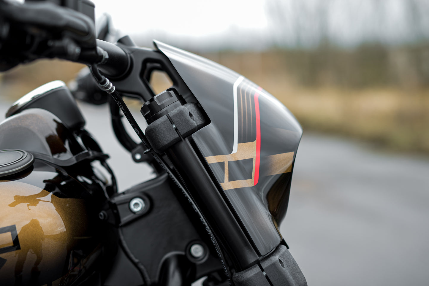 Zoomed Harley Davidson motorcycle with Killer Custom fat bob headlight fairing blurry background