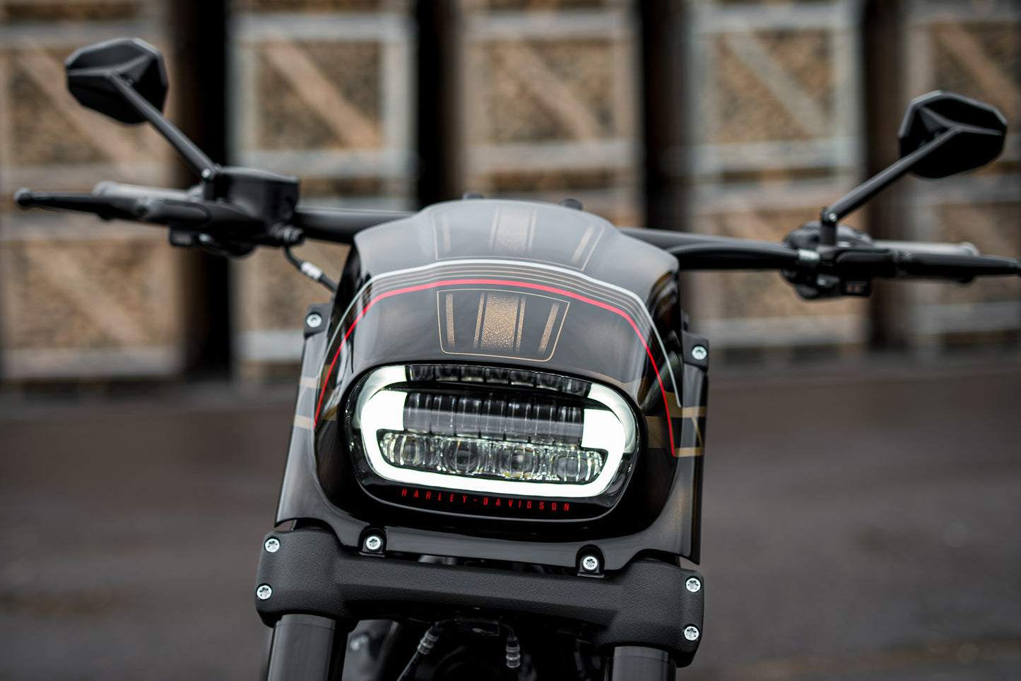Zoomed Harley Davidson motorcycle with Killer Custom fat bob headlight fairing in an industrial environment
