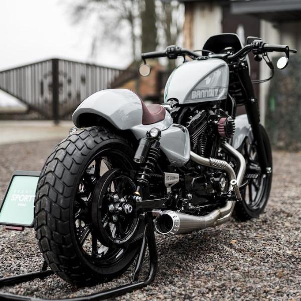 Harley Davidson motorcycle with Killer Custom sportster gas tank cover from the rear outside with visible fence and some trees in the background