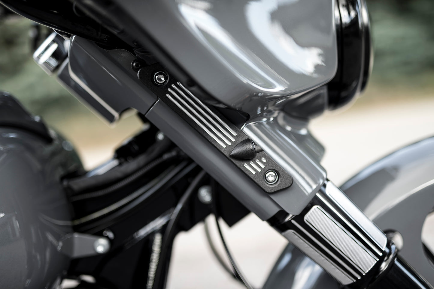 Zoomed Harley Davidson motorcycle with Killer Custom "Stripes" front LED turn signals from the side with a blurred nature background