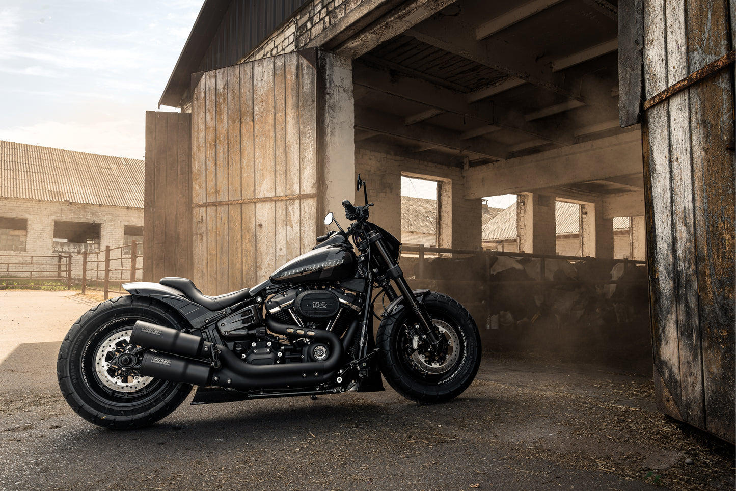 Harley Davidson motorcycle with "Bobbstr" rear fender from the side by Killer Custom on a farm environment
