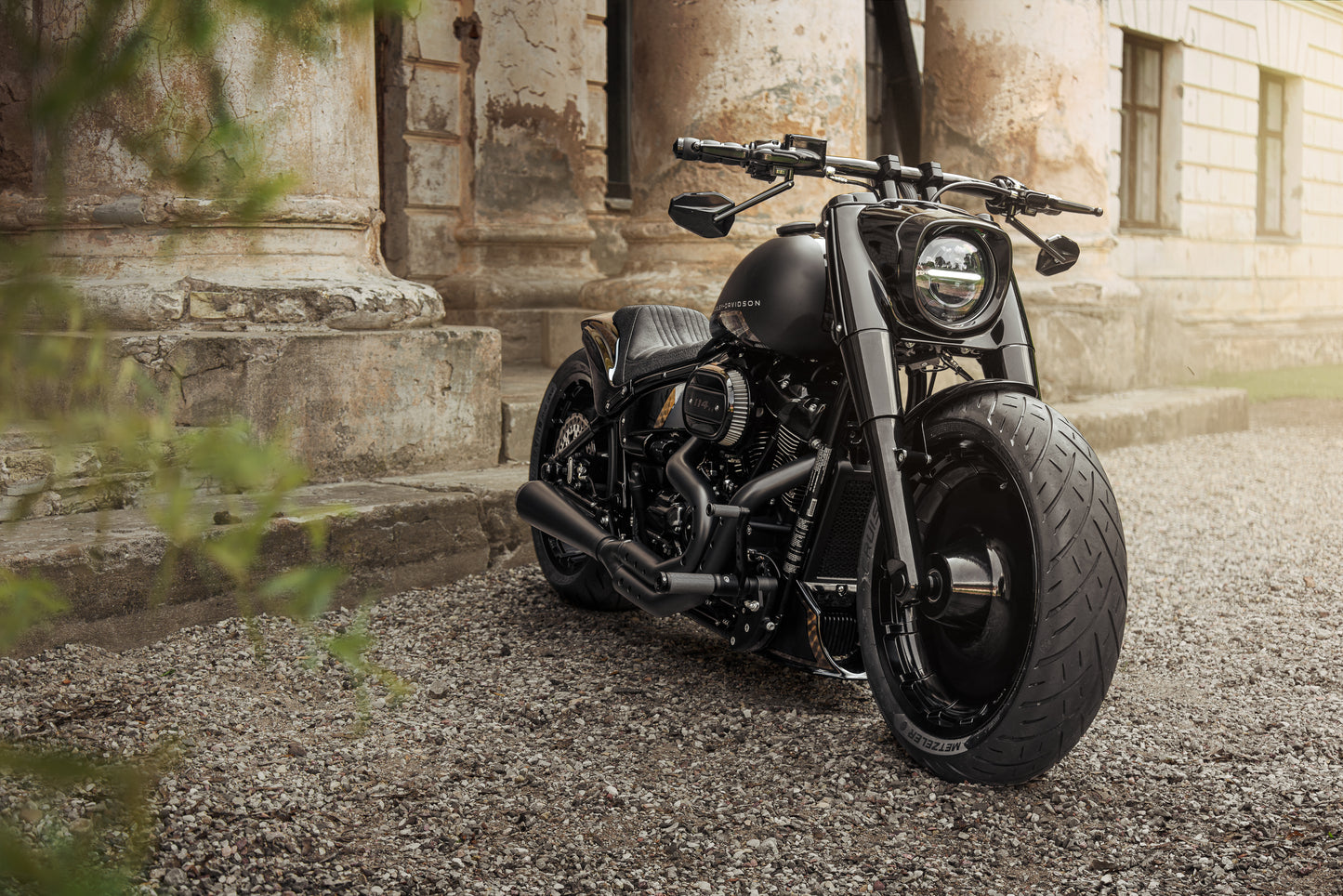 Harley Davidson motorcycle with Killer Custom riser set for handlebar from the front with an old mansion in the background