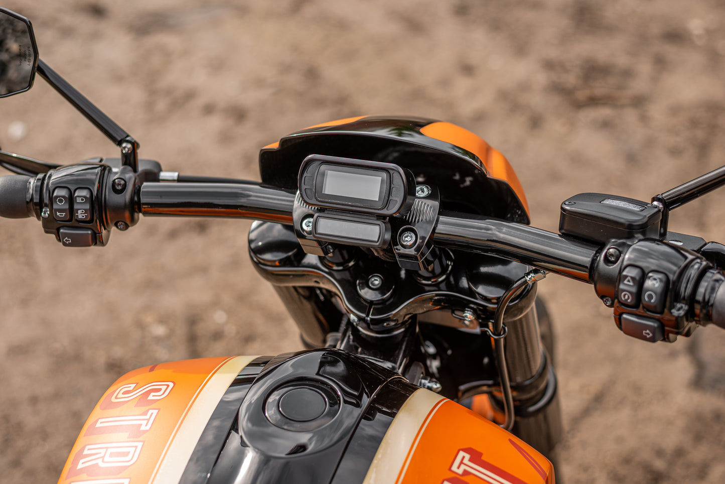 Zoomed Harley Davidson motorcycle with Killer Custom cluster-speedometer relocating housing from above brown blurry background