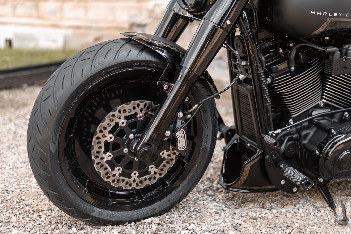 Zoomed Harley Davidson motorcycle with Killer Custom softail radiator cover from the side blurry background