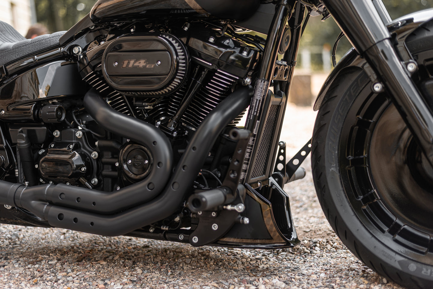 Zoomed Harley Davidson motorcycle with Killer Custom softail radiator cover from the side blurry background