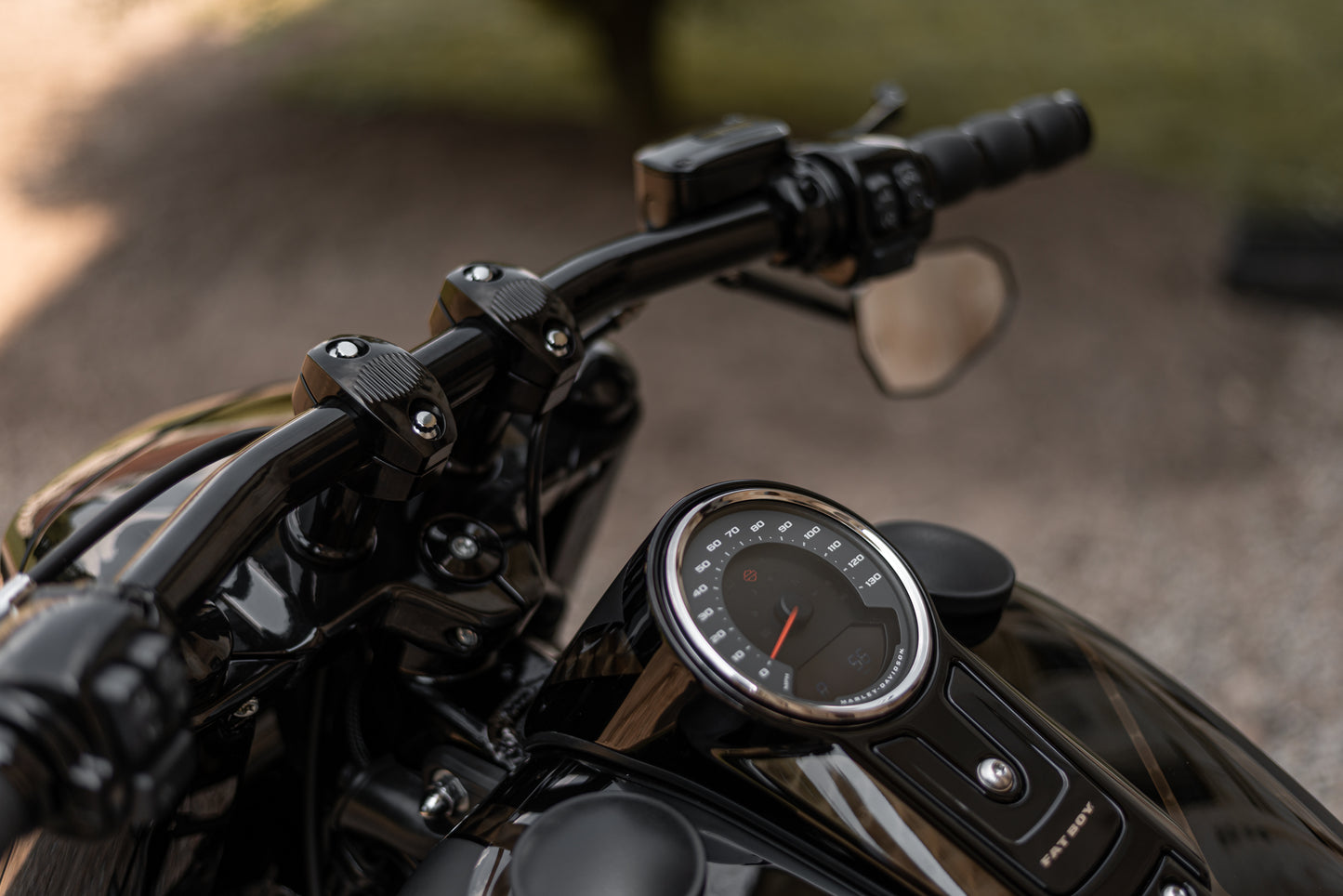 Zoomed Harley Davidson motorcycle with Killer Custom riser set for handlebar from above outside blurry background