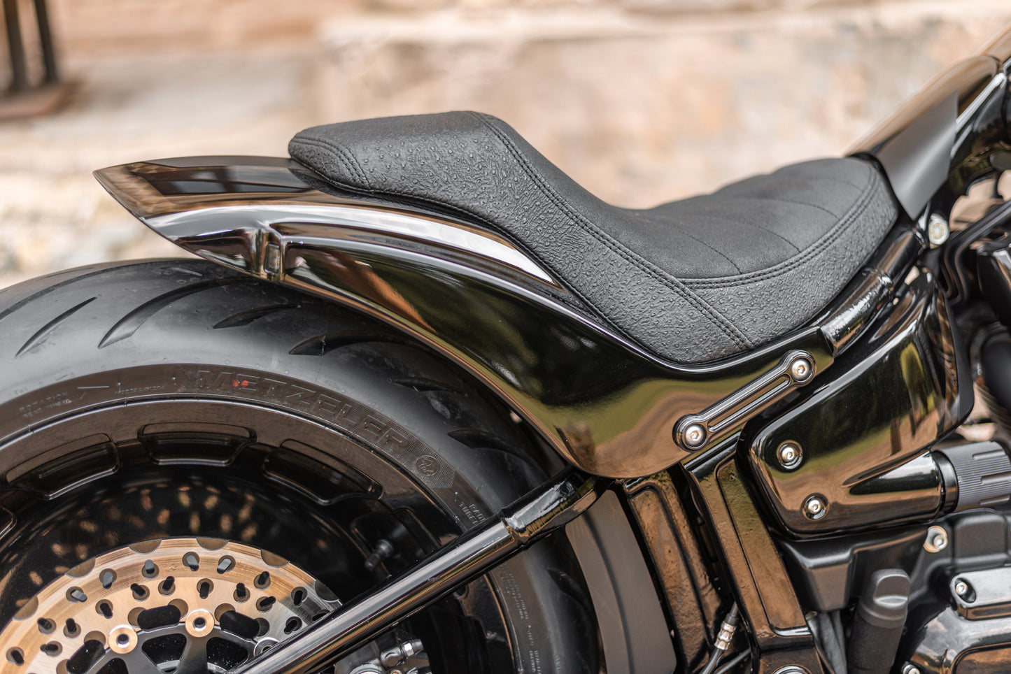 Zoomed Harley Davidson motorcycle with Killer Custom "Avenger" rear fender kit from the side blurred background
