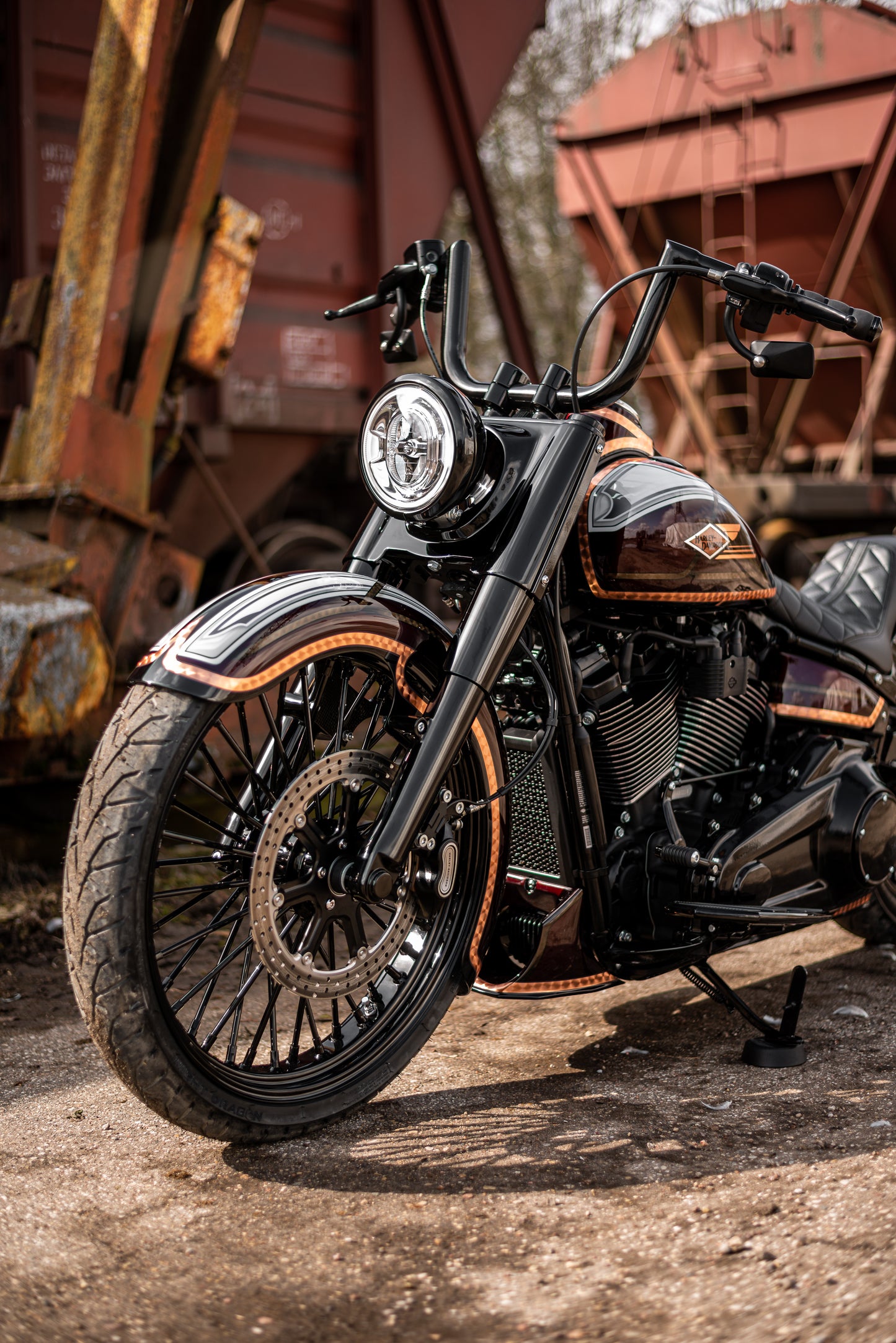 Harley Davidson motorcycle with Killer Custom front wrap fender from the front outside on a sunny day in an industrial environment