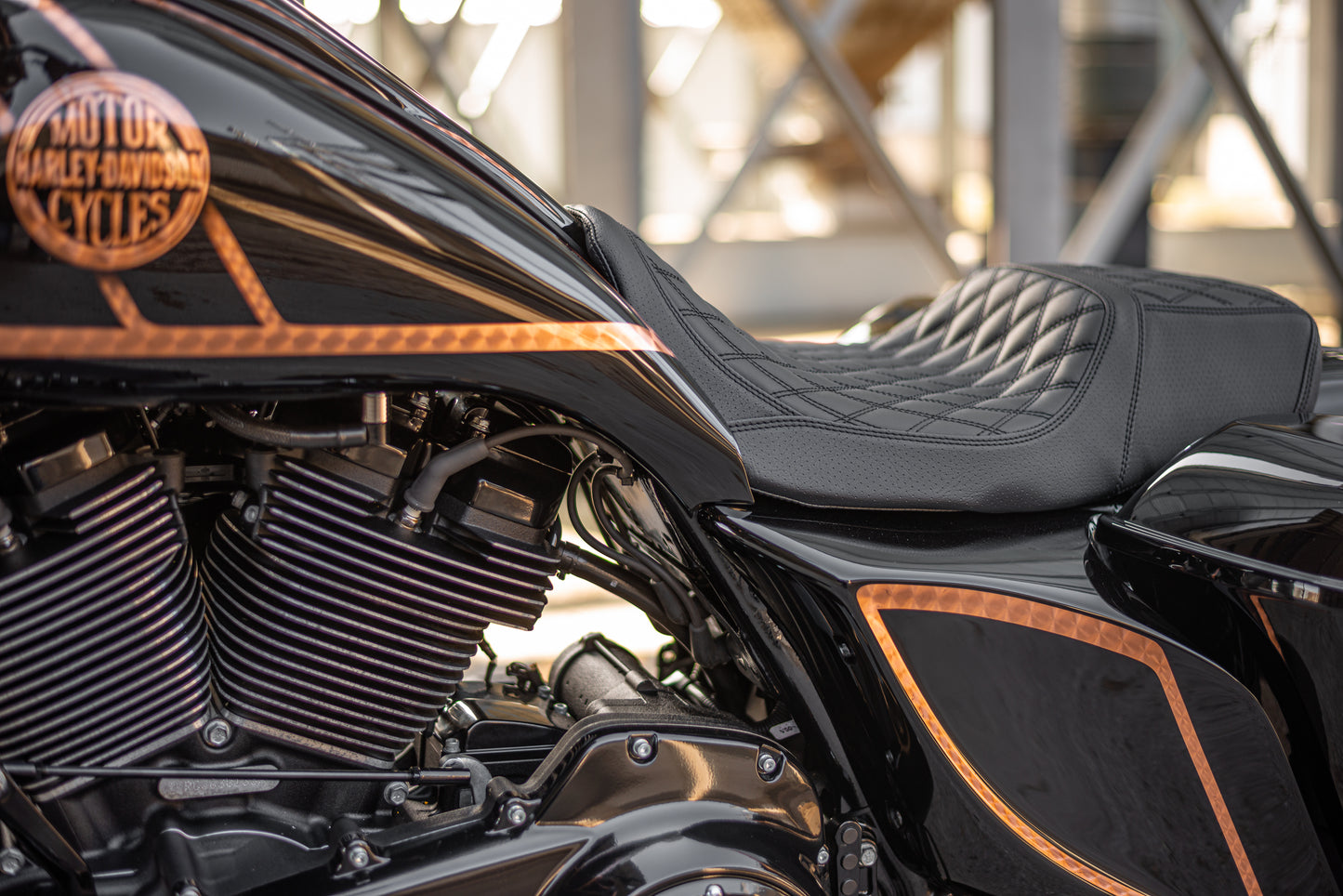 Zoomed Harley Davidson motorcycle with Killer Custom extended gas tank and side cover touring kit in an industrial environment