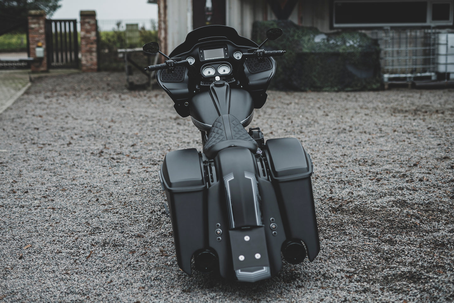 Harley Davidson motorcycle with Killer Custom touring rear fender with a garage and a fence in the background