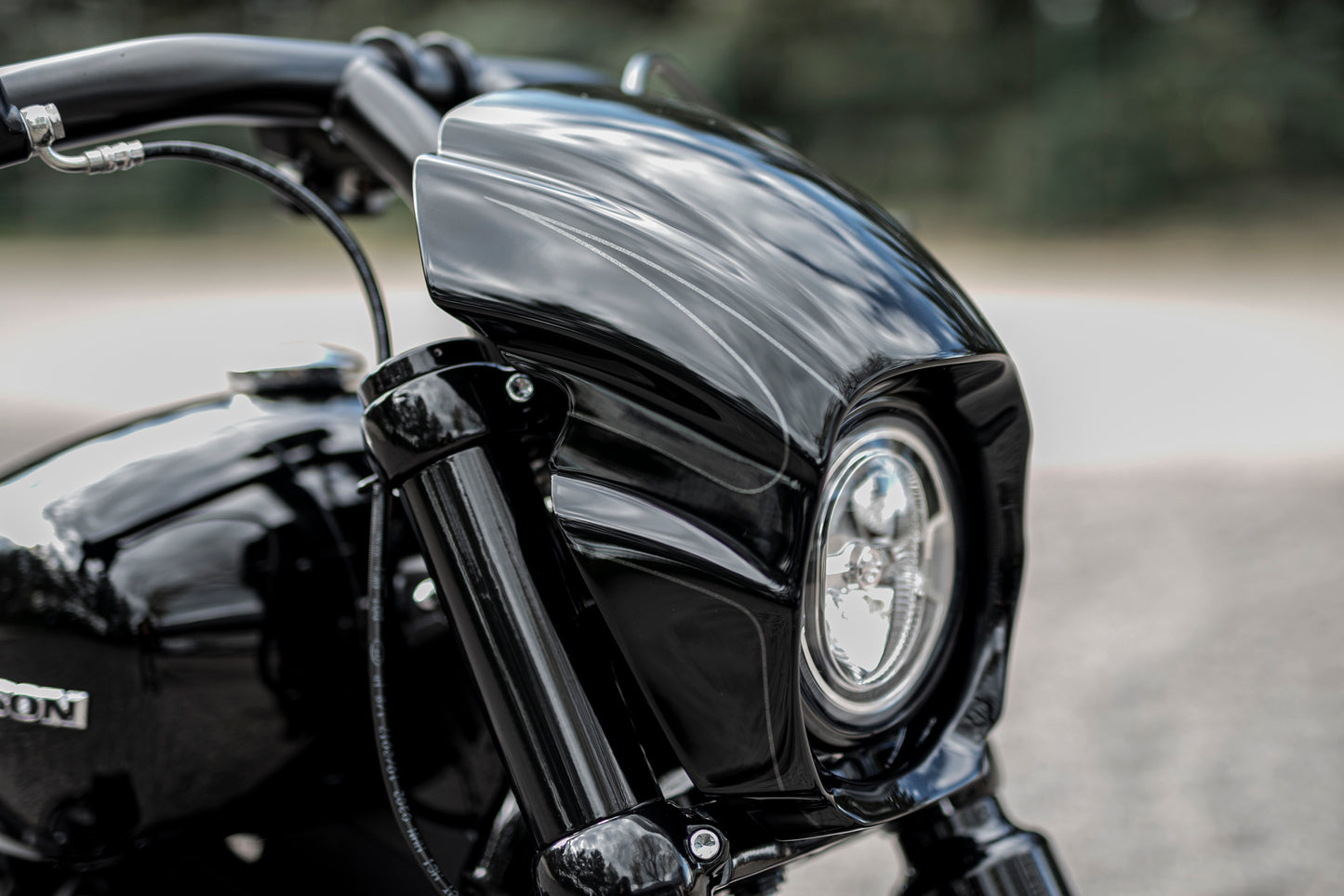 Zoomed Harley Davidson motorcycle with Killer Custom "Aggressor" headlight fairing from the front blurry background