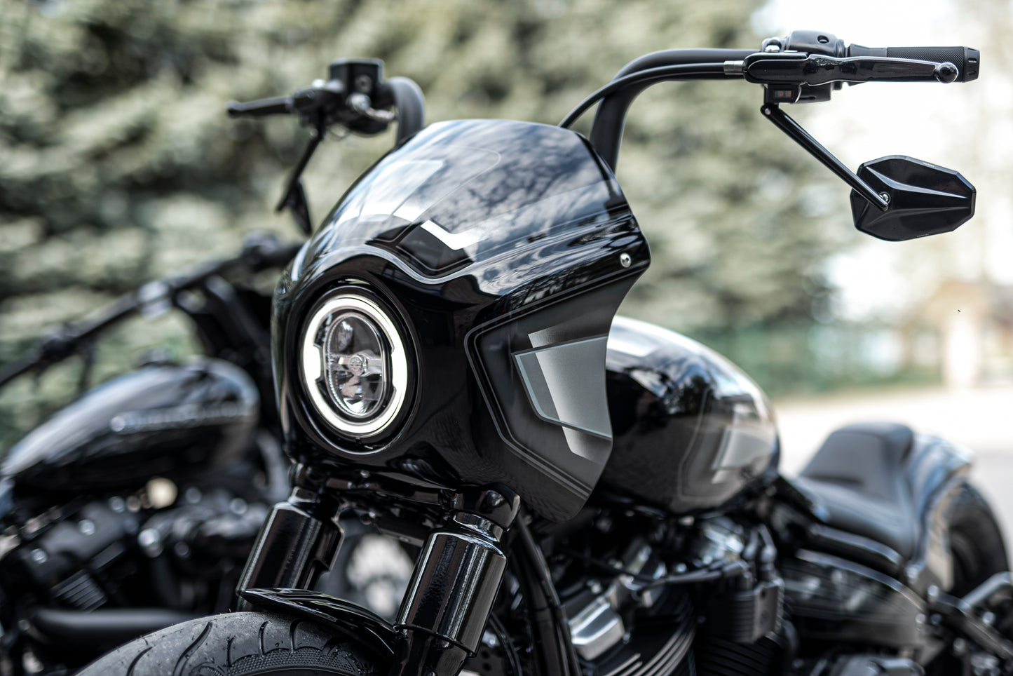 Zoomed Harley Davidson motorcycle with Killer Custom booster mirrors from the front blurry nature background