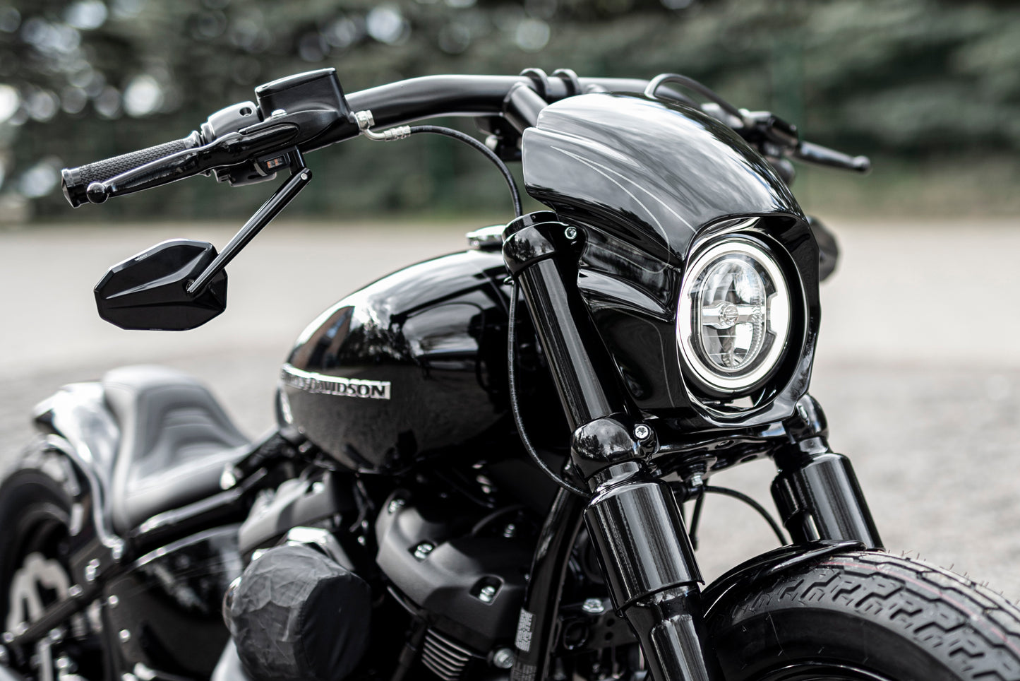 Zoomed Harley Davidson motorcycle with Killer Custom booster mirrors from the front in a nature environment