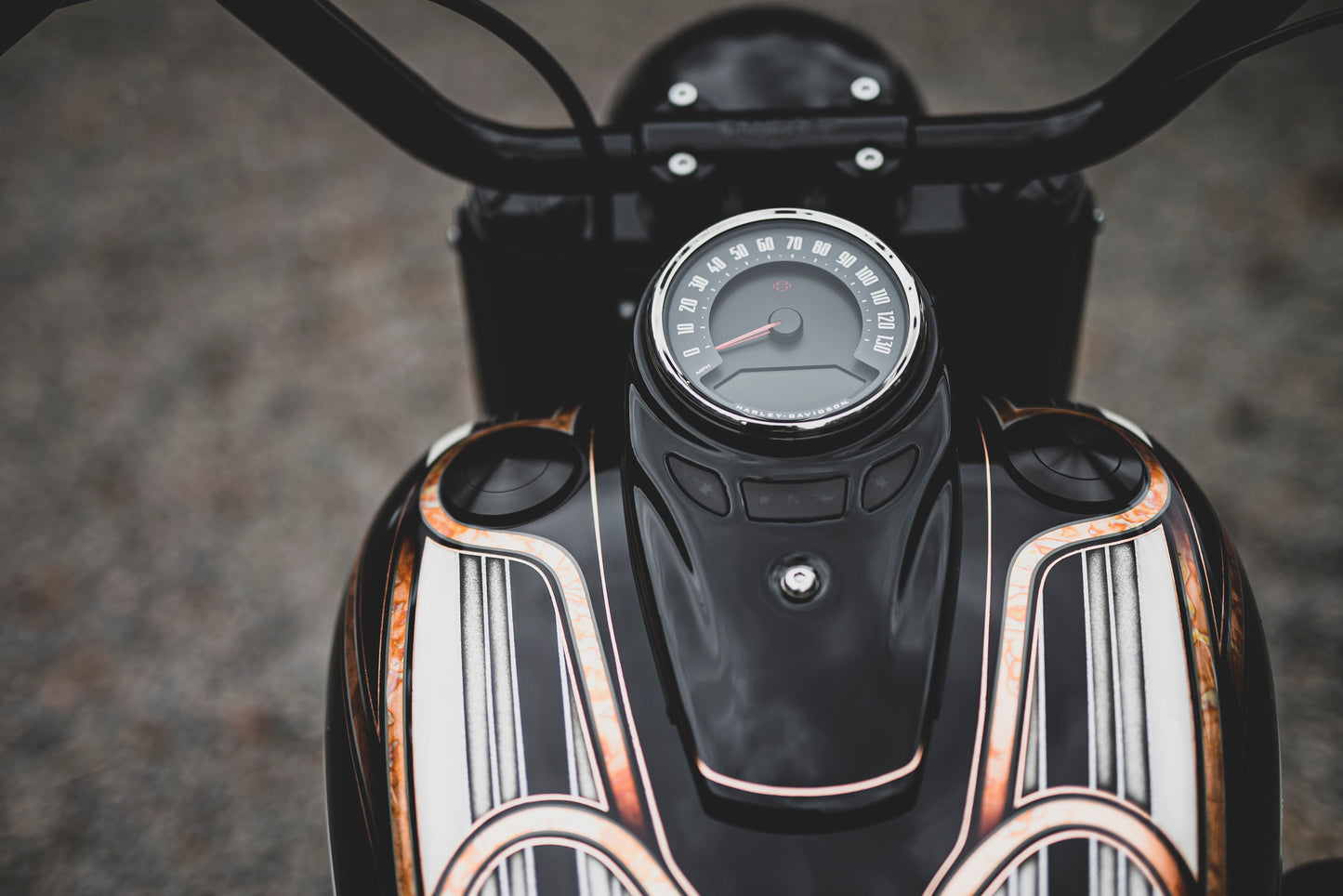 Zoomed Harley Davidson motorcycle with Killer Custom flush-mount fuel cap and left side tank cap kit from above blurry background