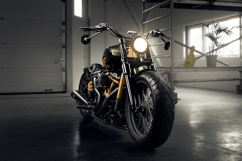Harley Davidson motorcycle with Killer Custom wide triple trees set from the front in a spacious and modern garage
