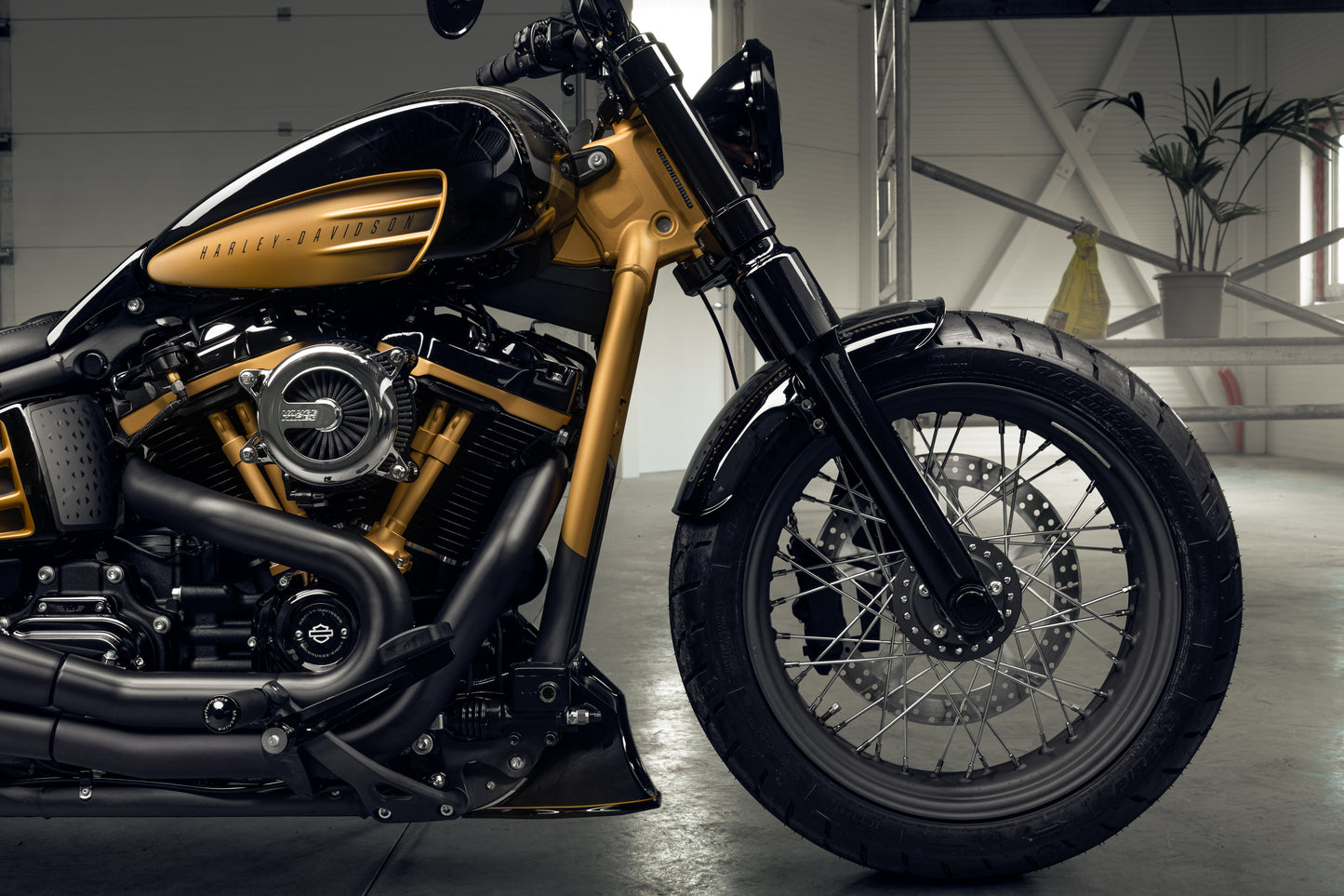 Harley Davidson motorcycle with Killer Custom wide triple trees set from the side in a spacious and modern garage