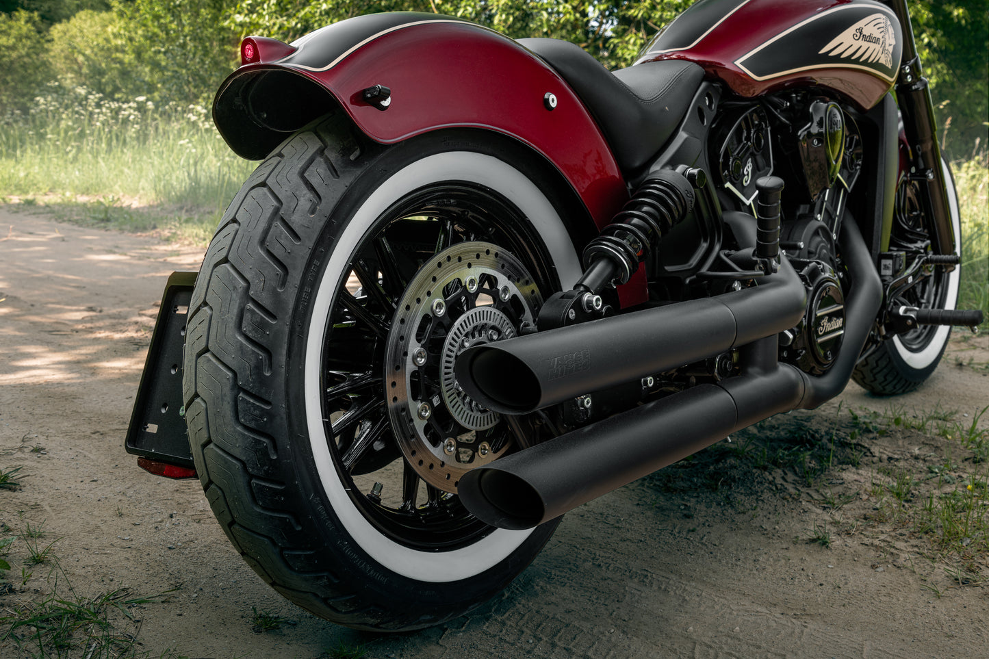 Harley Davidson motorcycle with Killer Custom "Apache" rear fender from the rear on the forest ruts