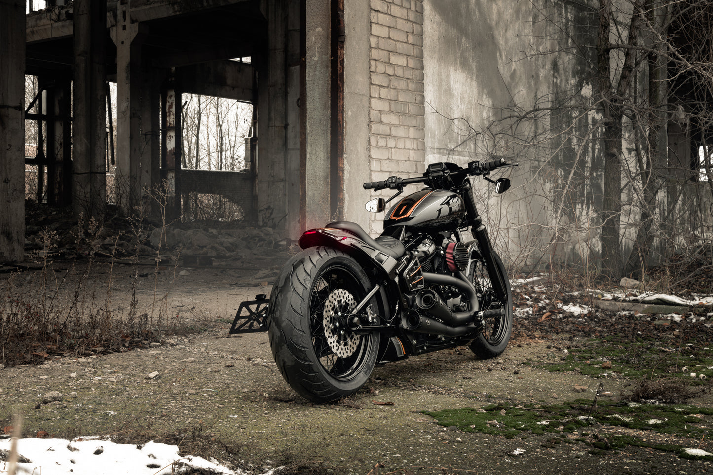 Harley Davidson motorcycle with Killer Custom  running/brake/turn signals - taillight from the rear outside in an abandoned environment