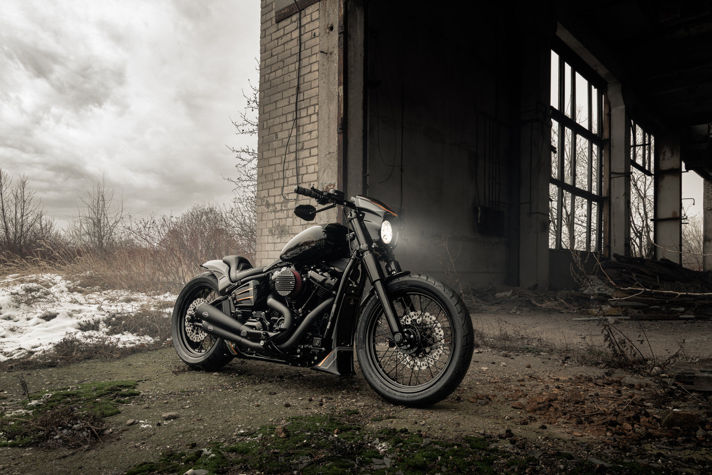 Harley Davidson motorcycle with Killer Custom "Aggressor" full fork cover set from the side outside on a gloomy day in an abandoned environment