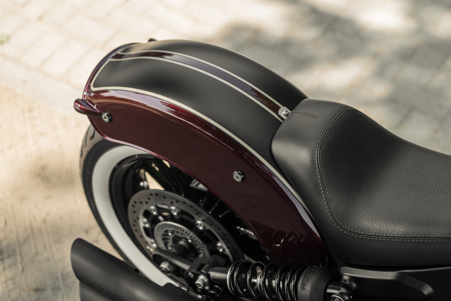 Zoomed Harley Davidson motorcycle with Killer Custom "Apache II" rear fender from above blurry background