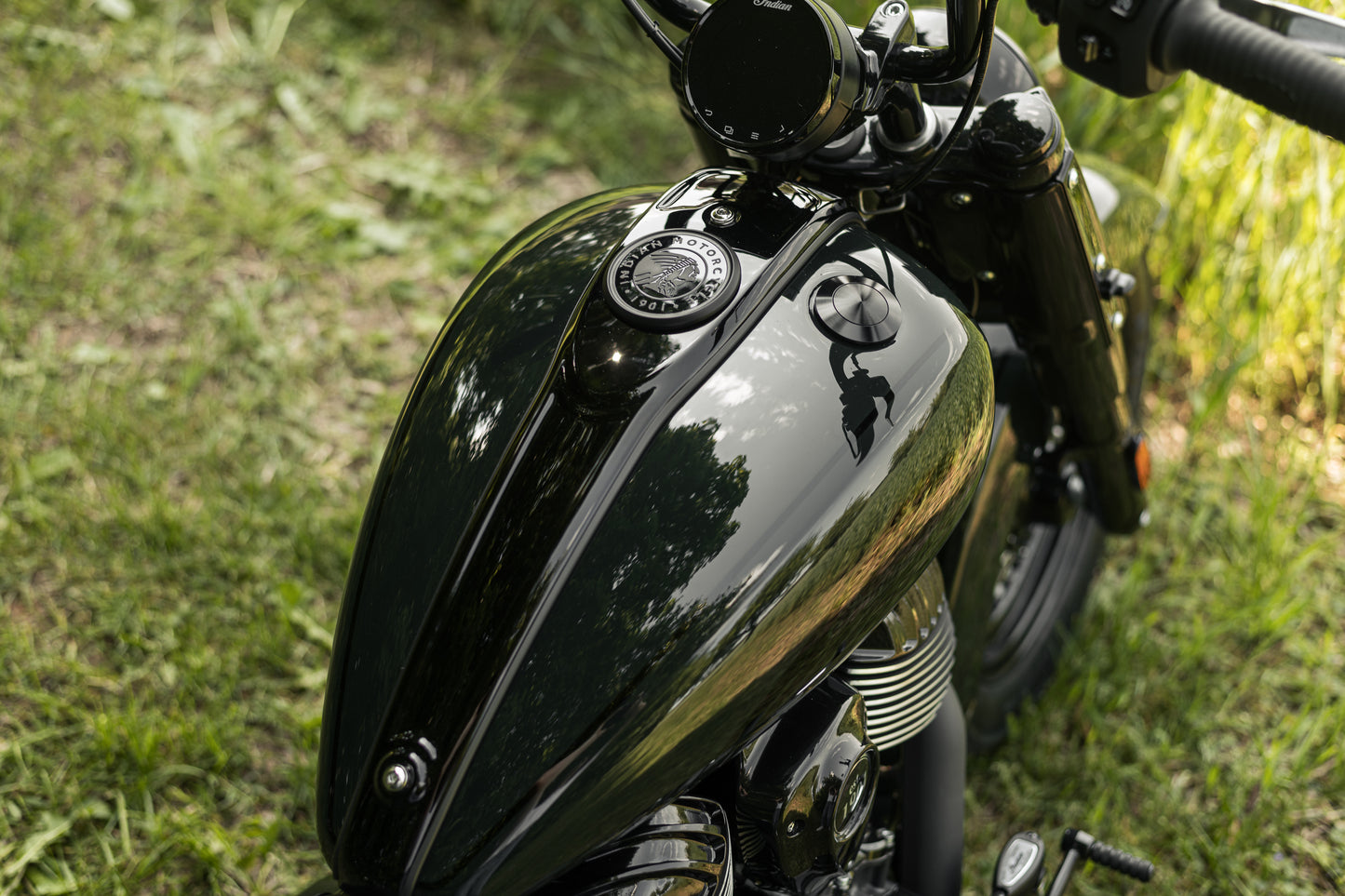 Zoomed Harley Davidson motorcycle with Killer Custom flush mount pop-up gas cap from above with blurred grass in the background