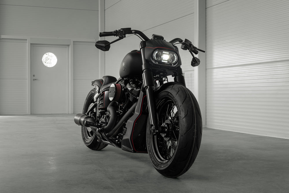 Harley Davidson motorcycle with Killer Custom wide triple trees set from the front in a spacious and modern garage
