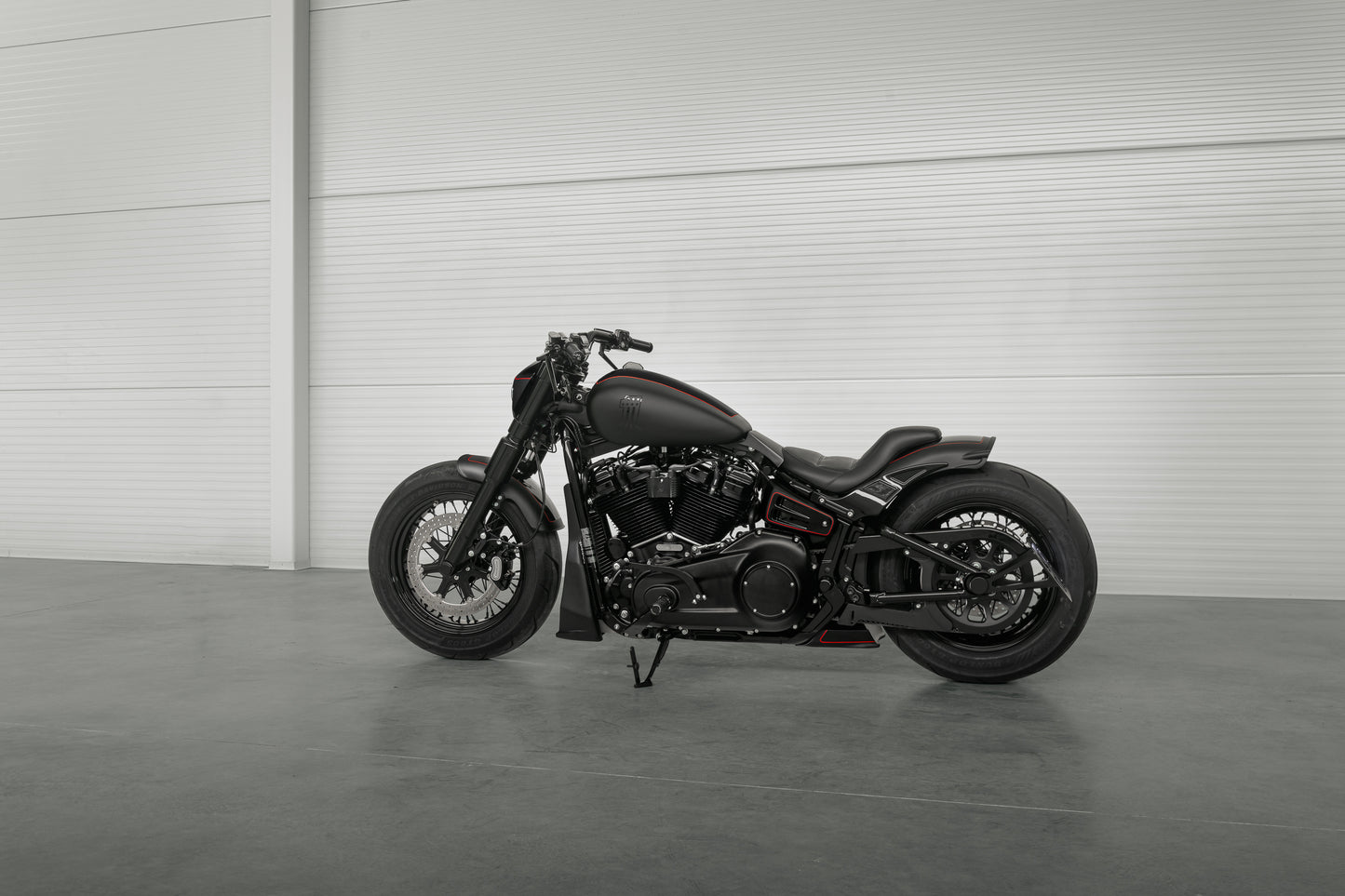 Harley Davidson motorcycle with Killer Custom wide triple trees set from the side in a spacious and modern garage