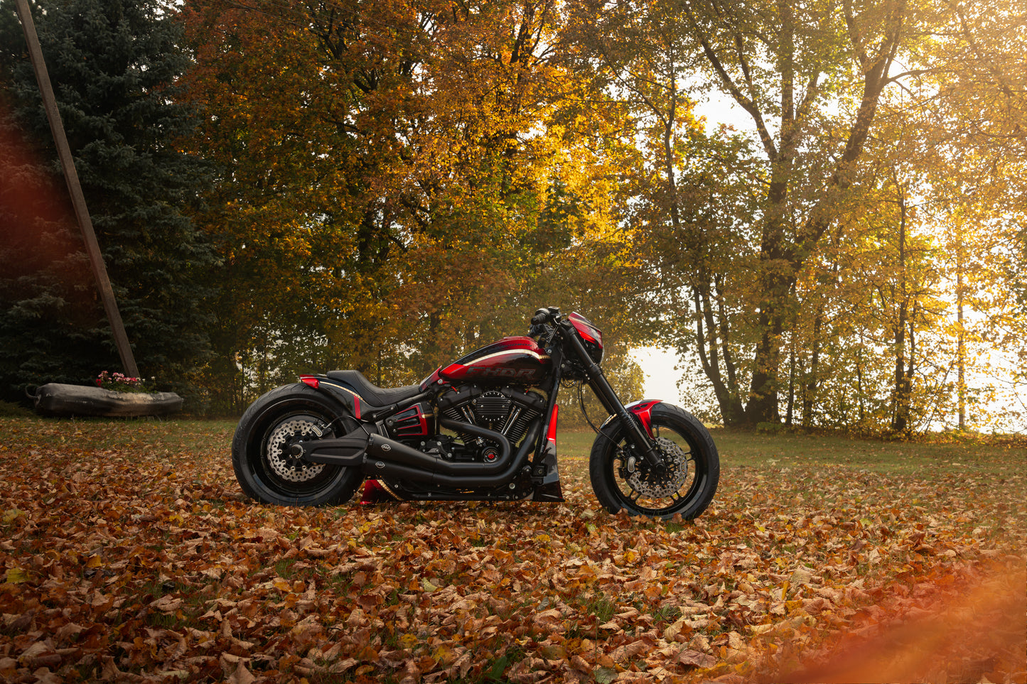 Harley Davidson motorcycle with Killer Custom "Avenger" front fender from the side outside with some trees and fallen leaves in the background