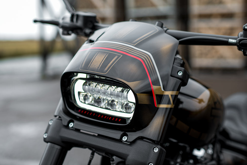 Zoomed Harley Davidson motorcycle with Killer Custom fat bob headlight fairing from the front blurry background
