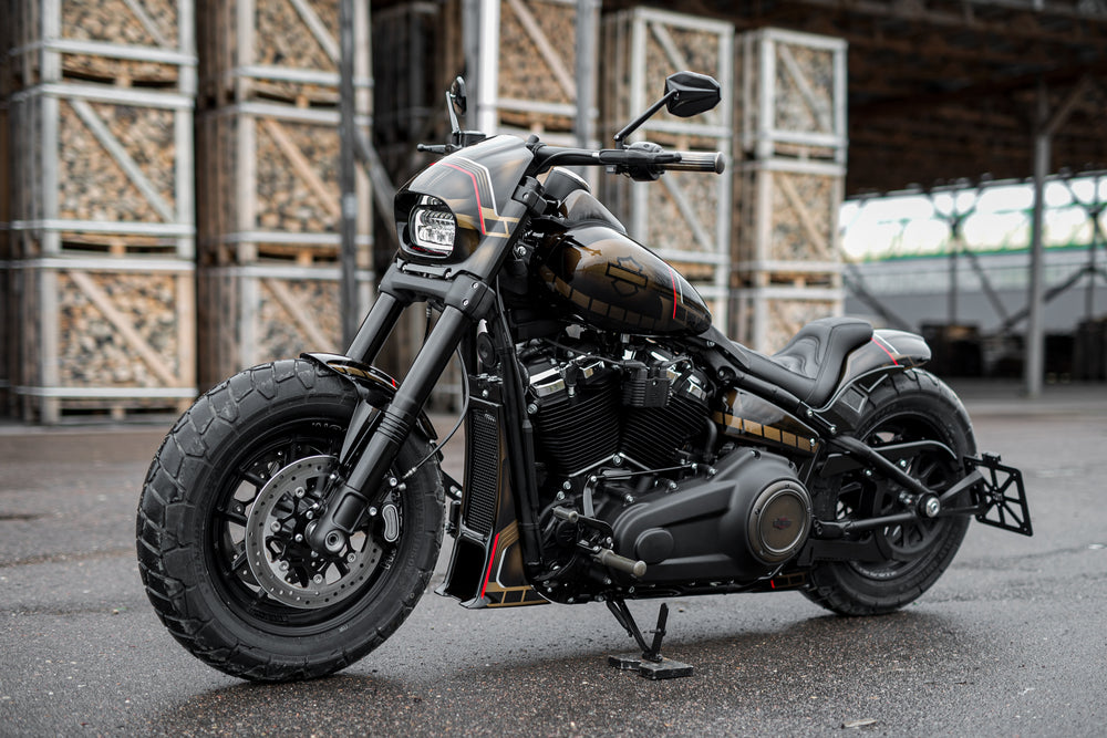 Harley Davidson motorcycle with Killer Custom fat bob headlight fairing from the side in an industrial environment